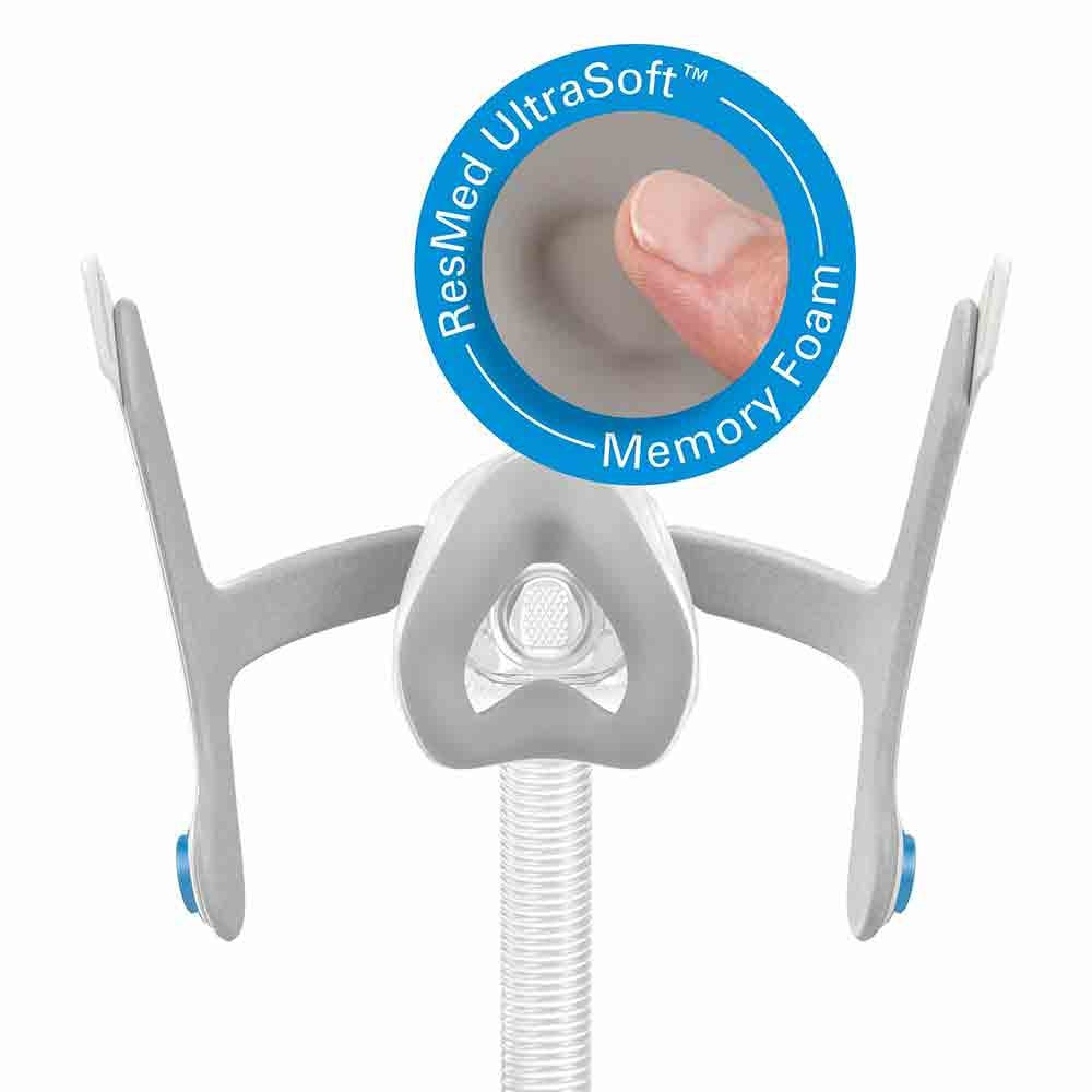 Complete AirTouch N20 nasal mask with headgear and tube, next to a ResMed UltraSoft memory foam badge