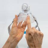 Hands pressing a new AirFit F20 cushion onto the mask frame, with the headgear still attached