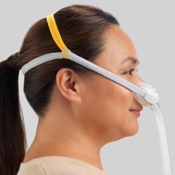 Fisher & Paykel Solo Nasal CPAP Mask being worn by a woman sleeping on her side, showing the AutoLock seal.