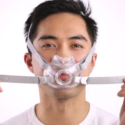 Photo of a man fitting the AirFit F30, holding both lower straps out to the sides