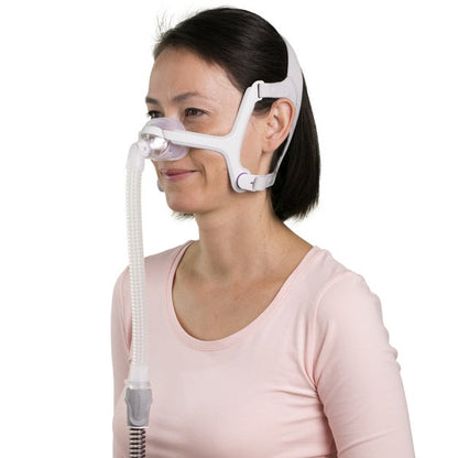 Side photo of a woman wearing the AirFit N20 For Her, its lavender headgear wrapping the back of her head