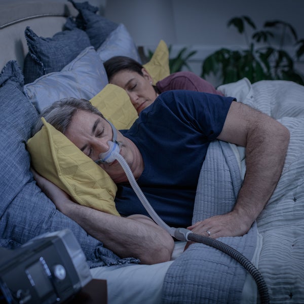 Photo of a man asleep on his side in the AirFit N30, with his partner sleeping beside him