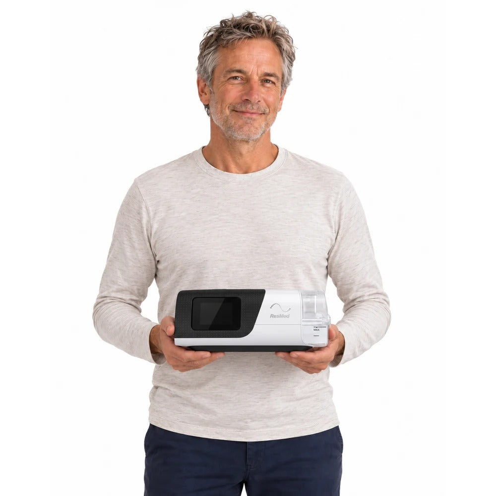 Photograph of a man in a light sweater holding the AirSense 11 AutoSet in both hands to show its size