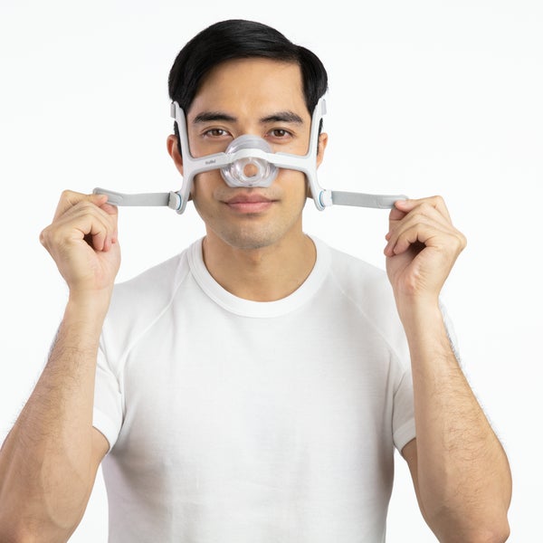 Photo of a man fitting the AirTouch N20, holding the lower headgear straps out to either side