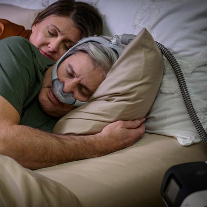 Photo of a man asleep on his side in the AirTouch N30i, with his partner resting behind him