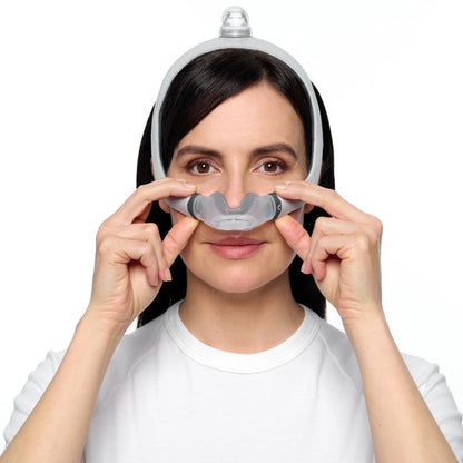 Photo of a woman settling the AirTouch N30i cushion under her nose with both hands