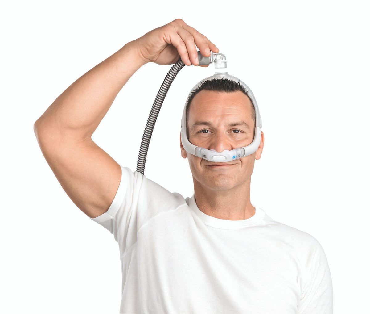 Photo of a man wearing the AirFit P30i, clipping his hose into the elbow on top of his head