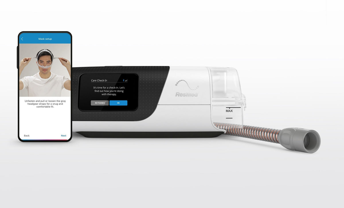 ResMed AirSense 11 with the ClimateLineAir 11 heated tube plugged in, beside a phone showing the mask setup screen