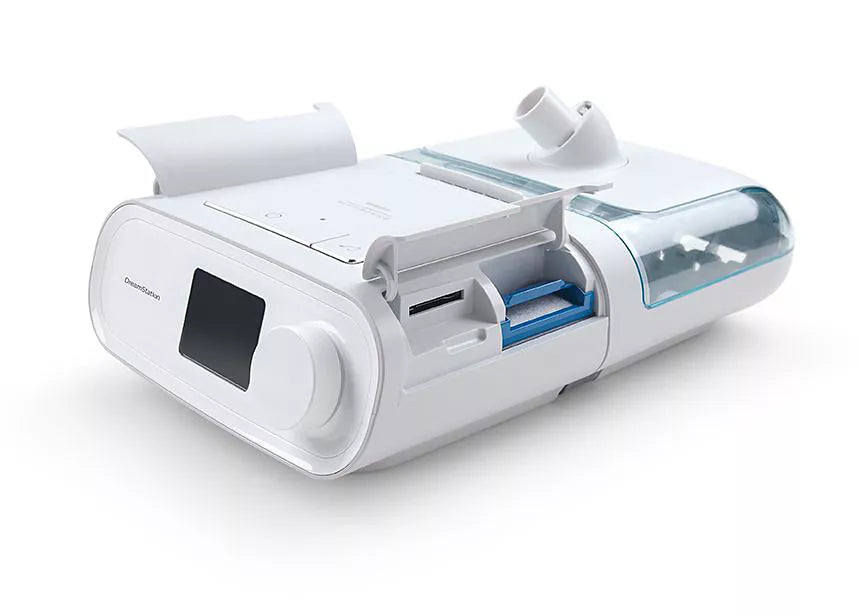 Side view of the original DreamStation and humidifier with the lid raised, showing the blue-tinted water chamber inside
