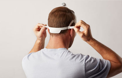 Rear photo of a man adjusting the DreamWear headgear strap at the back of his head