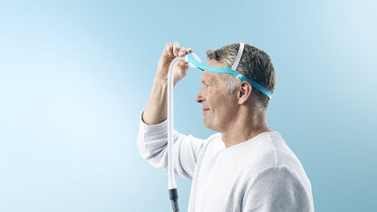 Profile photo of a man adjusting the Evora Nasal top strap above his ear