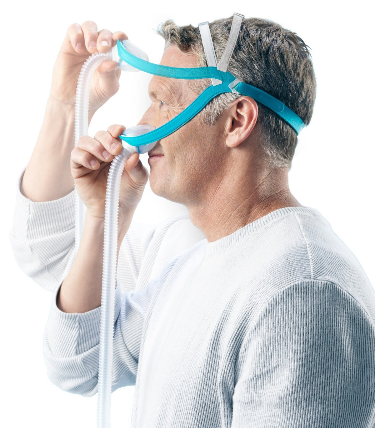 Side photo of a man pulling the Evora Nasal back strap over his head while fitting it