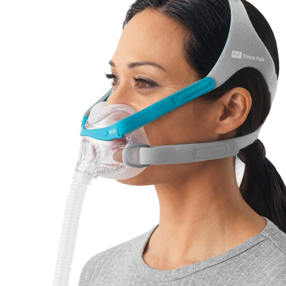 Woman wearing the Evora Full mask, side view, with the blue upper strap and grey lower strap visible