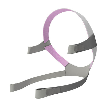 Angled view of the AirFit F10 For Her headgear, grey straps with a pink crown and four fastening tabs