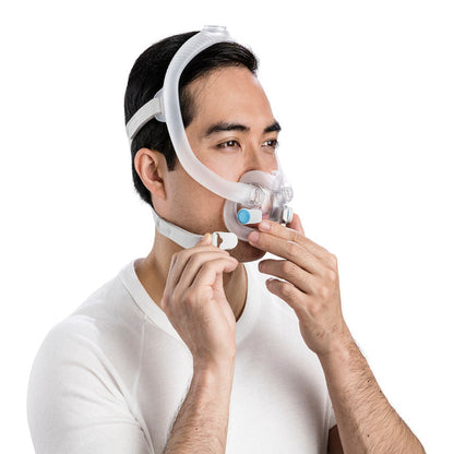 Man fitting an AirFit F30i, pressing a magnetic headgear clip onto the frame beside his mouth