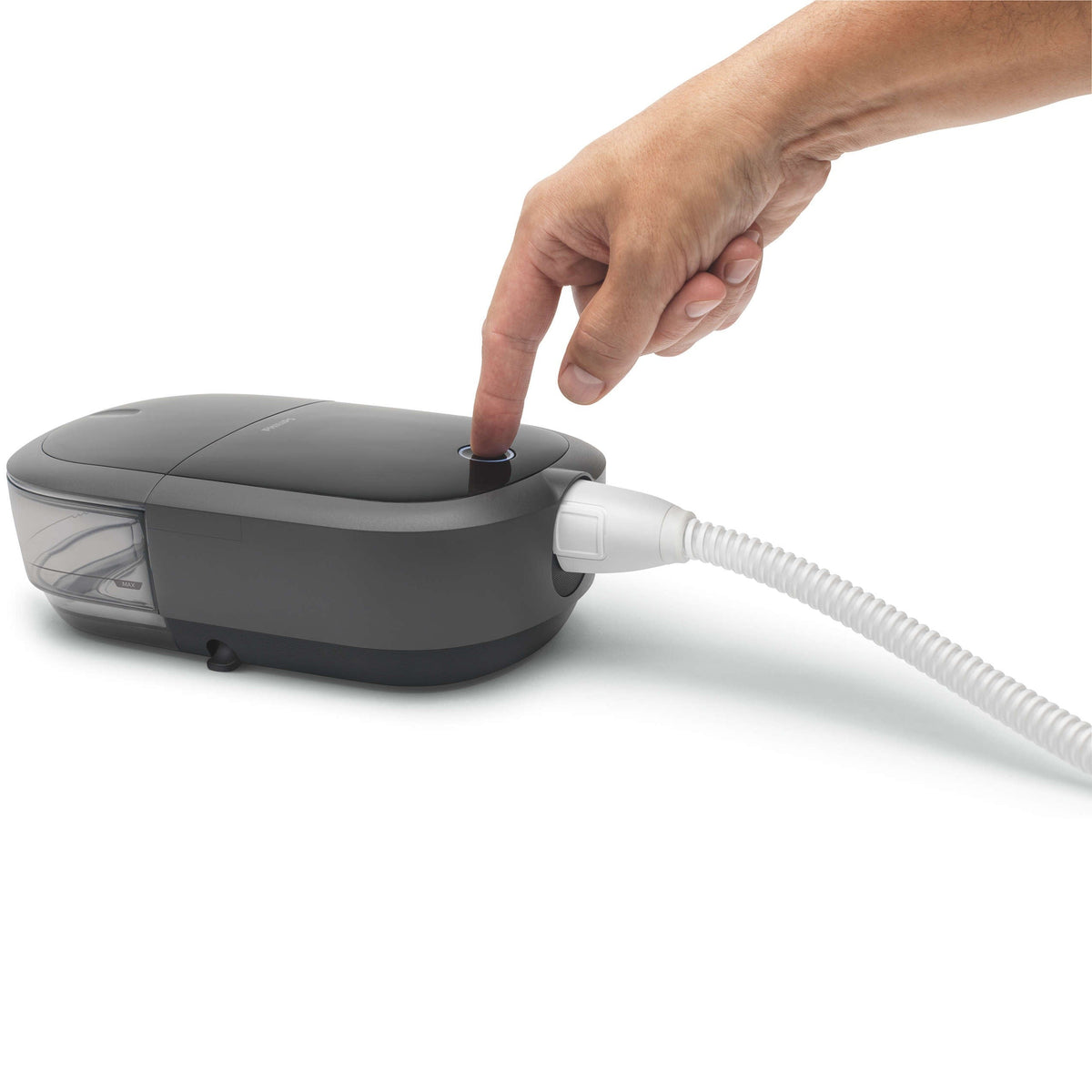 A hand pressing the start button on a DreamStation 2 with the slim heated tube attached at the side