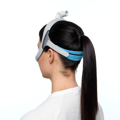 Rear view of a woman wearing an AirFit N30i, the blue headgear band sitting below her high ponytail