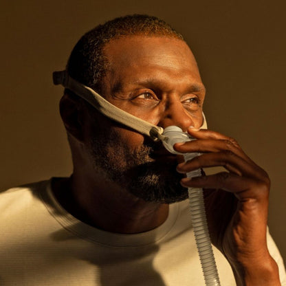 Man wearing the AirFit P10 nasal pillows mask, with the pillows seated at his nostrils