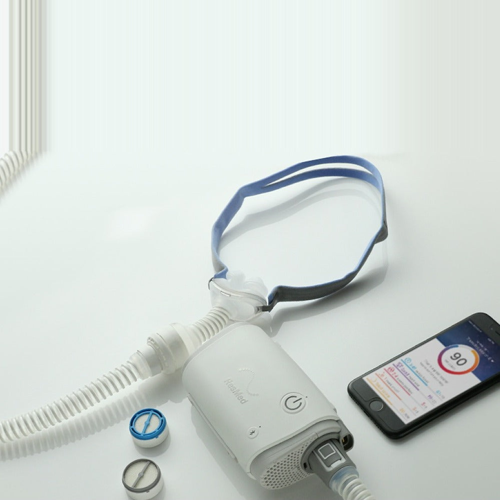 Overhead photo of the AirFit P10 for AirMini on an AirMini, beside a HumidX, a HumidX Plus and the app