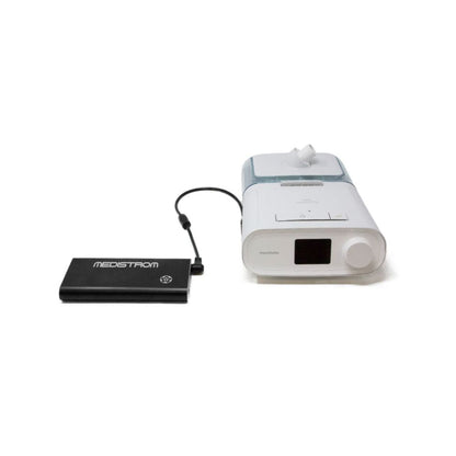 Pilot Flex battery in Charcoal connected by its output cable to a Philips CPAP machine with humidifier