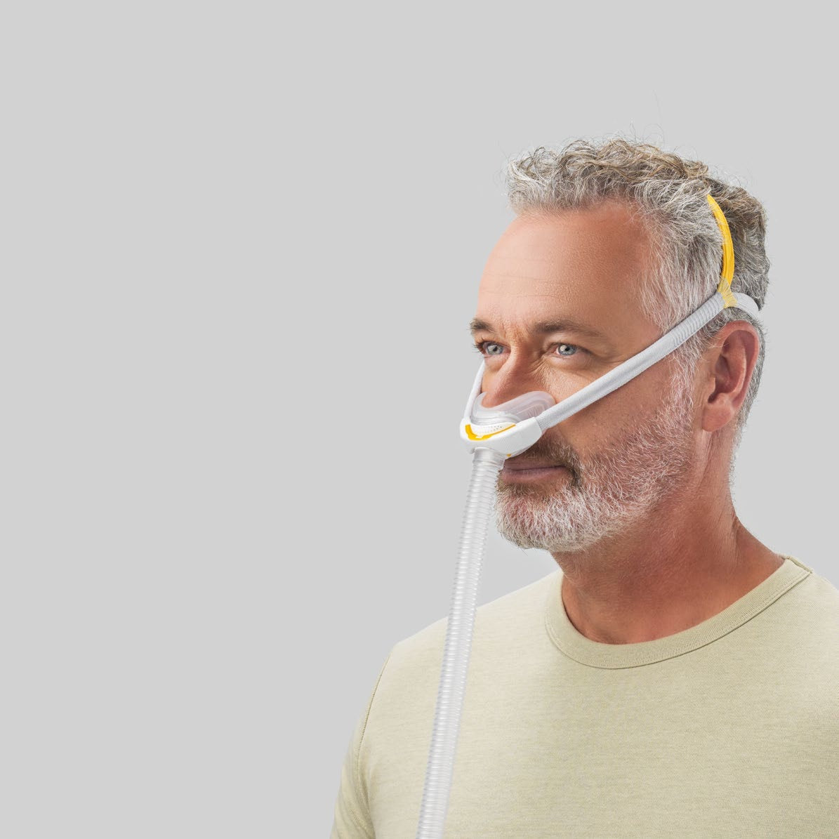 Side photo of a man wearing the Solo Nasal, with the orange strap across the top of his head