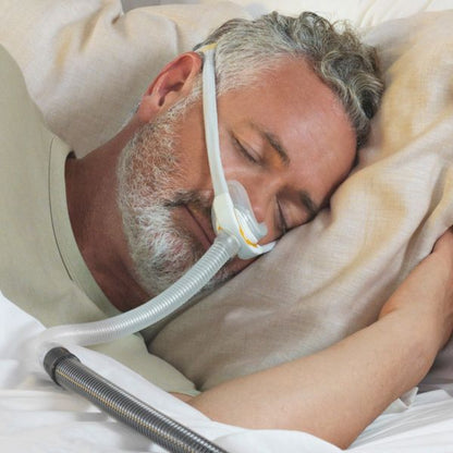 Fisher & Paykel Solo Nasal CPAP Mask with headgear on a man sleeping peacefully on his side.