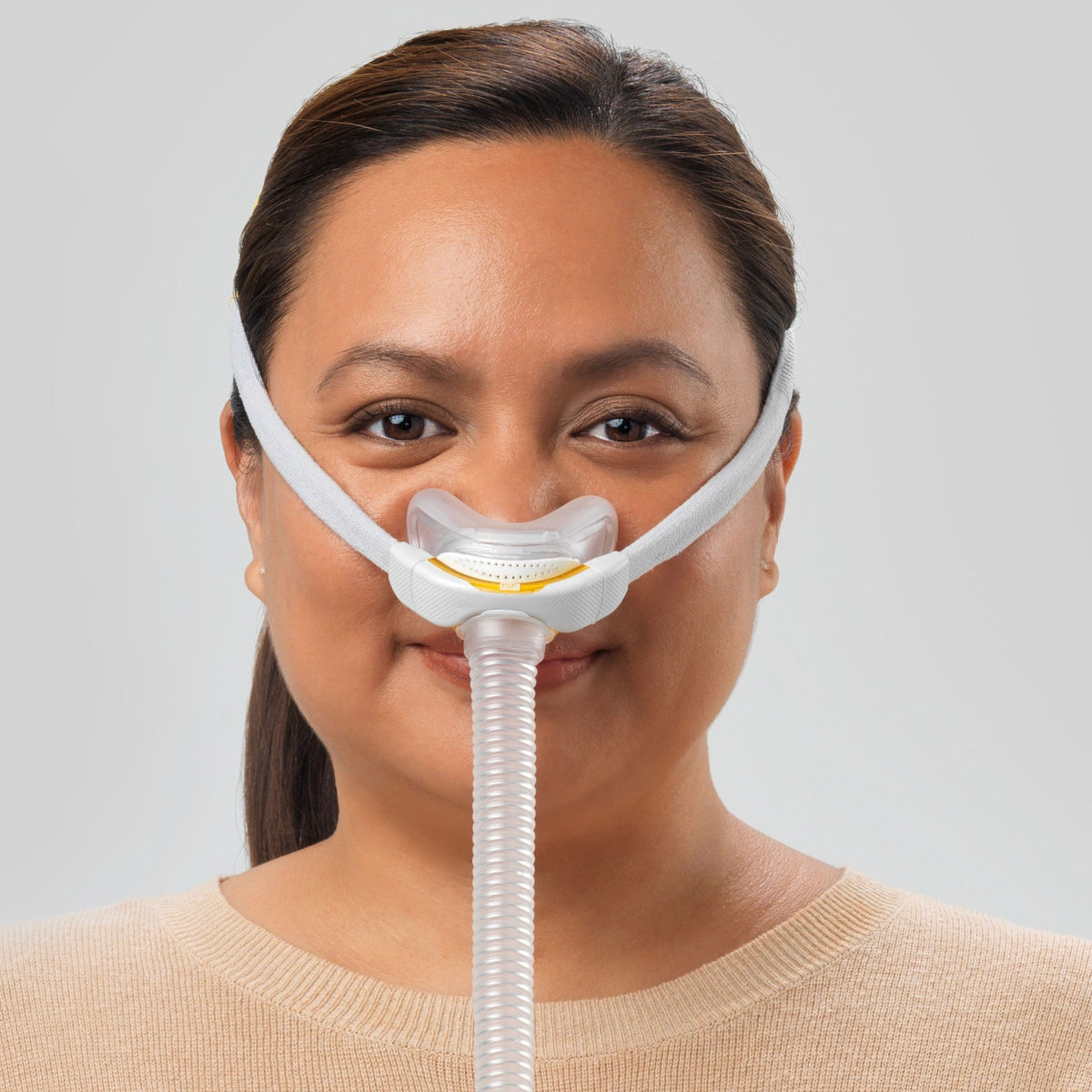 Photo of a woman wearing the Solo Pillows, facing forward, the cushion sitting at the base of her nose