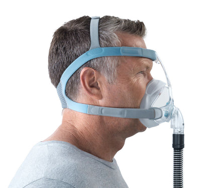 A man in profile wearing the Vitera mask, the blue forehead strap and cheek straps sitting level above his ear